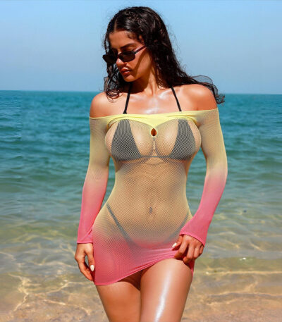 A model wearing a black long sleeve fishnet bodycon mini dress with hollow out mesh details as a sexy beach cover up and intimate nightwear.
