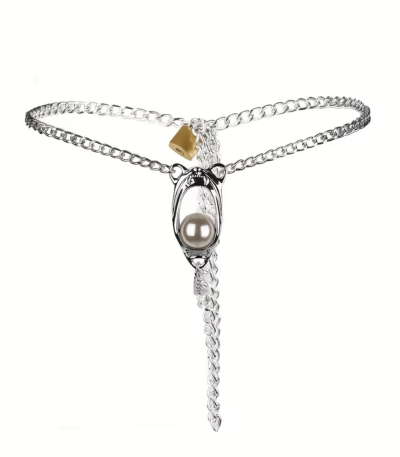 Polished stainless steel metal chastity underwear belt featuring an integrated lock mechanism and smooth freshwater pearl decor arranged on a white vanity space.