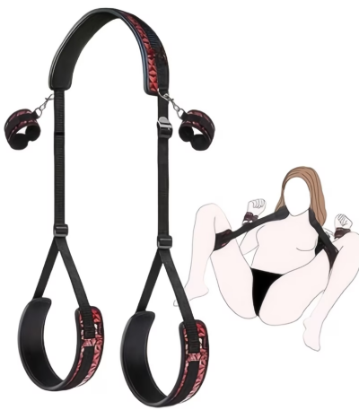 Black adjustable restraint kit featuring handcuffs and ankle cuffs with soft padded lining connected to unique diamond-patterned suspenders displayed on a bed.