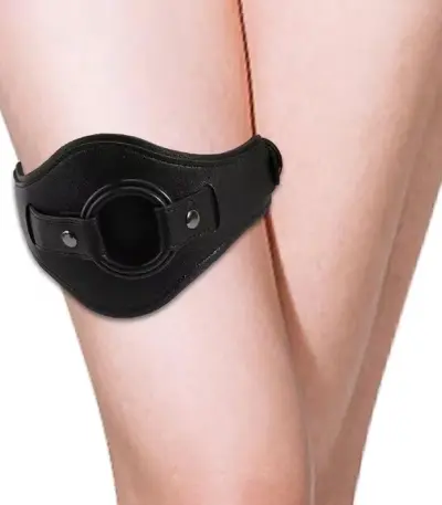 Black adjustable faux leather thigh band with built-in O ring worn on leg for indoor couple use
